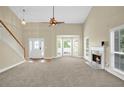 Open-concept living room with a fireplace, large windows, high ceilings, and a staircase at 4000 Mcpherson Drive, Acworth, GA 30101