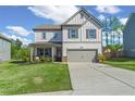Charming two-story home showcasing a well-manicured lawn, attached two-car garage, and inviting covered front porch at 150 Ivy Chase Loop, Dallas, GA 30157