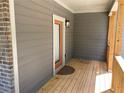Cozy covered porch with wood flooring, gray siding, and brick accents at 5950 Lynfield Dr, Atlanta, GA 30349