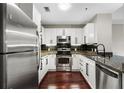 Galley kitchen with stainless steel appliances, white cabinets, granite counters, and hardwood floors at 325 E Paces Ferry Ne Rd # 313, Atlanta, GA 30305