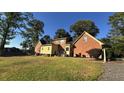 A spacious backyard with mature trees surrounds a brick and siding home, offering outdoor space at 3765 Cannonwolde Dr, Snellville, GA 30039