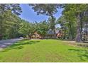 Spacious front yard with a view of the brick home and tree coverage at 3765 Cannonwolde Dr, Snellville, GA 30039