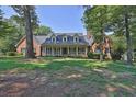 Well-maintained brick home with a front porch and mature trees at 3765 Cannonwolde Dr, Snellville, GA 30039
