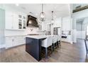 Stylish kitchen with white cabinets, a dark island with seating, and modern pendant lighting above the island at 00 Memory Ln, Canton, GA 30115