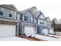 New townhomes showcasing modern architecture, a two-car garage, and manicured landscaping at 2304 Shetley Creek Dr, Norcross, GA 30071