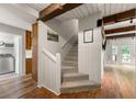 Bright hallway featuring wooden beams, a staircase, and access to the laundry room at 4018 Dunbarton Ne Way, Roswell, GA 30075