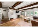 Cozy living room with exposed beams, fireplace, and access to the outdoor deck at 4018 Dunbarton Ne Way, Roswell, GA 30075