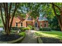 Beautiful brick home with lush landscaping, a well-maintained lawn, and a welcoming walkway at 110 Wellington Way, Canton, GA 30115
