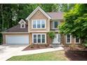 Stunning two-story house featuring lush greenery, a spacious driveway, and a charming stone-accented entrance at 313 Clubhouse Nw Ct, Kennesaw, GA 30144