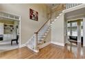 Light-filled foyer with hardwood floors, a staircase, and an open view into other rooms of the house at 5980 Whitestone Ln, Suwanee, GA 30024