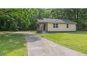 The house has a long driveway, surrounded by greenery and a well-manicured lawn at 525 Baker Nw Cir, Atlanta, GA 30318