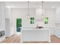 Bright, white kitchen with an island, stainless steel appliances, and hardwood floors at 614 Glendale Rd, Scottdale, GA 30079