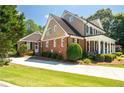 Stately brick home with a side-entry garage, manicured landscaping, and timeless elegance at 395 Grove Ridge Dr, Loganville, GA 30052
