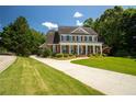 Inviting two-story home with a spacious front yard, long driveway, and classic architectural design at 395 Grove Ridge Dr, Loganville, GA 30052