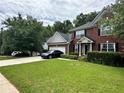 Charming brick home with a two-car garage, black shutters and lush, green front lawn at 627 Arbour Way, Suwanee, GA 30024