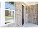 Beautiful front entrance with a dark wood door, modern windows and a grey brick exterior at 1517 Ellie Ridge Ave, Lawrenceville, GA 30043