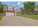 Inviting two-story home featuring a brick and siding facade, attached two-car garage, and a spacious driveway at 6341 Stewart Ridge Walk, Buford, GA 30518