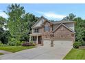 Attractive two-story home with stone and brick accents, lush landscaping, and a spacious two-car garage at 204 Starwood Ct, Acworth, GA 30102