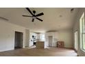Bright, open-concept living space flowing into a modern kitchen, featuring hardwood floors and a ceiling fan at 325 Garrison Se Dr, Marietta, GA 30060
