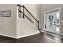 Inviting foyer featuring hardwood floors, elegant staircase, and white front door with glass panes at 675 Mallard Cv, Loganville, GA 30052