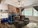 Inviting living room showcasing a brick fireplace, built-in shelves, and natural light from large windows at 224 Potts Se Rd, Conyers, GA 30094