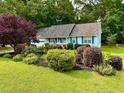 Charming one-story home with blue siding and a beautifully landscaped front yard and mature trees at 60 Parkman Trl, Covington, GA 30016