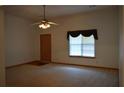 Bright living room featuring neutral carpet, a ceiling fan, and a window bringing in lots of light at 60 Parkman Trl, Covington, GA 30016