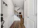 Bright foyer with hardwood floors, white wainscoting, and staircase with black iron spindles at 5575 Hedge Brook Dr, Cumming, GA 30028