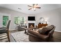 Cozy living room with fireplace, plush seating, and natural light from large windows at 5575 Hedge Brook Dr, Cumming, GA 30028
