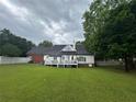 Spacious backyard featuring a well-maintained lawn, white fencing, and a deck perfect for entertaining at 3677 Malachi Way Way, Loganville, GA 30052