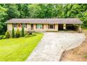 Charming single-story home featuring red accents, attached carport, and a well-maintained front yard at 100 Eldorado Dr, Carrollton, GA 30116
