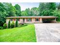 Charming single-story home featuring red accents, attached carport, and a well-maintained front yard at 100 Eldorado Dr, Carrollton, GA 30116