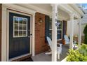 Charming front porch featuring red brick, white pillars, and comfortable Adirondack chairs at 169 Wallnut Hall Circle, Woodstock, GA 30189