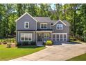 Two-story home features a well-manicured lawn, attached garage, front porch and lush, mature trees at 194 Saddleridge Dr, Bremen, GA 30110