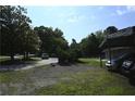 Long driveway with a carport provides plenty of parking spaces amidst mature trees at 1621 Oak Rd, Snellville, GA 30078