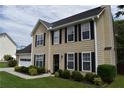View of a classic two-story house featuring tidy landscaping, neutral siding, and an attached two car garage at 3109 Windgate Dr, Buford, GA 30519