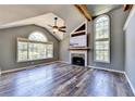 Bright living room with vaulted ceilings, a cozy fireplace, and large windows offering scenic views and new hard wood floors at 4751 Shay Ter, Buford, GA 30519