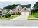 Traditional brick home with a manicured lawn, two-car garage, and inviting curb appeal at 665 Roxford Ln, Buford, GA 30518
