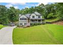 Spacious front yard featuring a well-maintained lawn and a charming two-story house with a welcoming front porch and beautiful landscaping at 1301 Ficklen Church Way, Canton, GA 30114