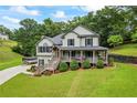 Well-manicured lawn leads to a charming two-story home, complete with a cozy front porch, perfect for relaxing and enjoying the outdoors at 1301 Ficklen Church Way, Canton, GA 30114