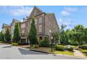 Brick townhome featuring a two-car garage with mature trees at 502 Abbington River Ln, Atlanta, GA 30339