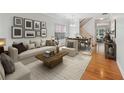 Bright living room features wood floors, neutral decor, stairway, and dining area with large window at 5937 Sharp Se Dr, Mableton, GA 30126