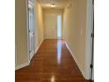 Inviting hallway with hardwood floors and a view of the front door with sidelight windows at 964 Village View Cir, Loganville, GA 30052