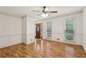 Bright and airy living room featuring hardwood floors, wainscoting, and multiple windows providing ample natural light at 1369 Willowbrook Sw Dr, Marietta, GA 30064