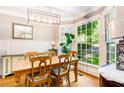 Dining room with wood table set beneath modern light fixture, adjacent to a large window at 404 Summerchase Way, Woodstock, GA 30189