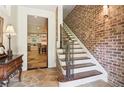 Inviting foyer with stone floors and an adjacent staircase with an ornate wrought iron banister at 5172 Roswell Rd, Marietta, GA 30062