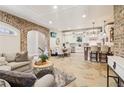 Open-concept living area with stone floors, a sofa, and a full kitchen with white cabinets at 5172 Roswell Rd, Marietta, GA 30062