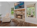 Cozy living room featuring a brick fireplace, mantel, and a relaxing armchair at 3455 Henderson Dr, Cumming, GA 30041