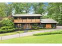 Beautiful exterior of a modern home featuring a brick driveway, lush landscaping, two-story entryway, and manicured lawn at 4601 Tall Pines Nw Dr, Atlanta, GA 30327