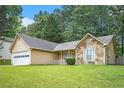 Single-story home featuring stone accents, a well-manicured lawn, and an attached two-car garage at 7847 Dogwood Way, Douglasville, GA 30134